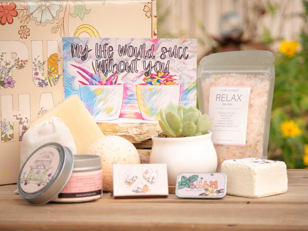 My life would succ without you Succulent Gift Box with relax bath salt, natural soap, bath bomb, shower steamer, candle, custom matches, lavender satchet and lip balm, in front of a decorative gift box