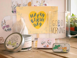 Sending you sunshine Gift Box with Good Morning Mug, candle, custom matches, lavender sachet and lip balm, in front of a decorative gift box