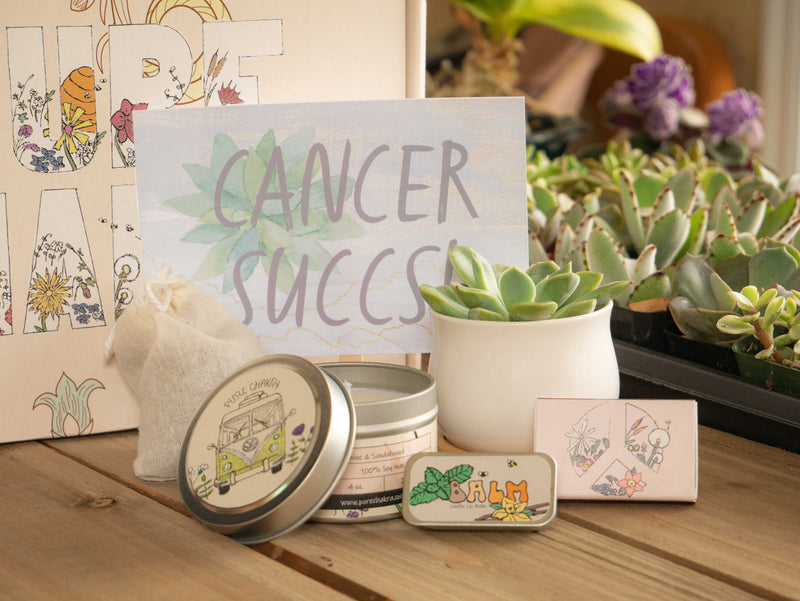 Cancer Succs Succulent Gift Box with candle, custom matches, lavender sachet and lip balm, in front of a decorative gift box