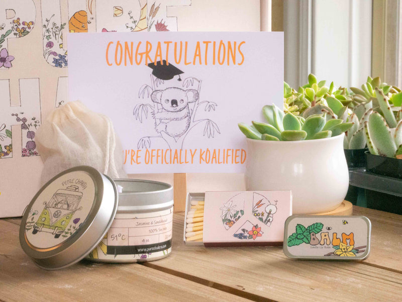 Congratulations you're officially koalified (qualified) Succulent Gift Box with candle, custom matches, lavender sachet and lip balm, in front of a decorative gift box