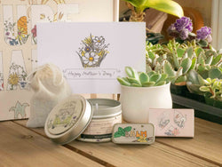 Happy Mother's Day Succulent Gift Box with candle, custom matches, lavender sachet and lip balm, in front of a decorative gift box