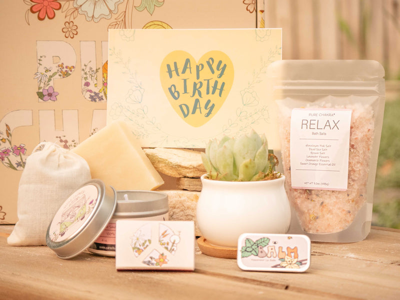 Happy Birthday Succulent Gift Box with relax bath salt, natural soap, candle, custom matches, lavender sachet and lip balm, in front of a decorative gift box