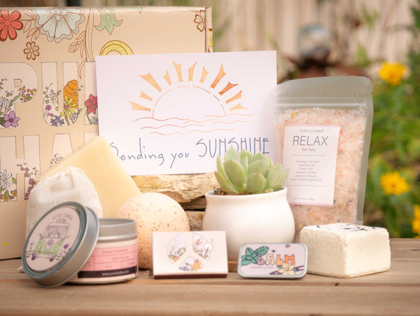 Sending you Sunshine Succulent Gift Box with relax bath salts, natural soap, bath bomb, shower steamer, candle, custom matches, lavender sachet and lip balm, in front of a decorative gift box