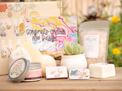 Congrats on the new baby Succulent Gift Box with relax bath salt, natural soap, bath bomb, shower steamer, candle, custom matches, lavender sachet and lip balm, in front of a decorative gift box