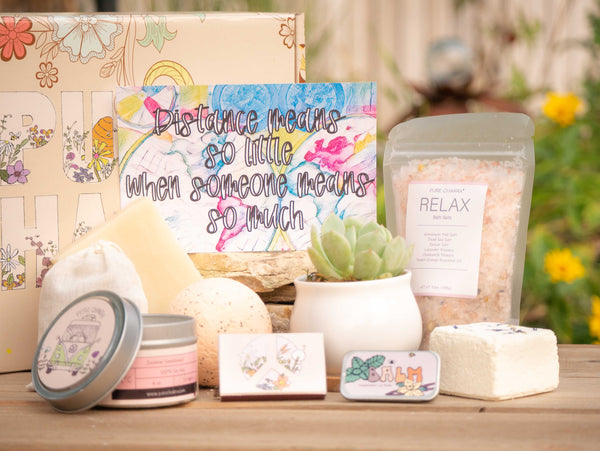 Distance means so little when someone means so much Succulent Gift Box with relax bath salt, natural soap, bath bomb, shower steamer, candle, custom matches, lavender satchet and lip balm, in front of a decorative gift box