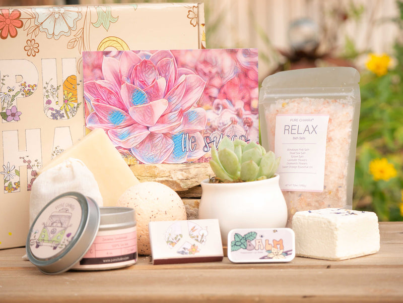 He succs Succulent Gift Box with relax bath salt, natural soap, bath bomb, shower steamer, candle, custom matches, lavender satchet and lip balm, in front of a decorative gift box