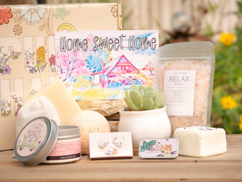 Home sweet home Succulent Gift Box with relax bath salt, natural soap, bath bomb, shower steamer, candle, custom matches, lavender sachet and lip balm, in front of a decorative gift box