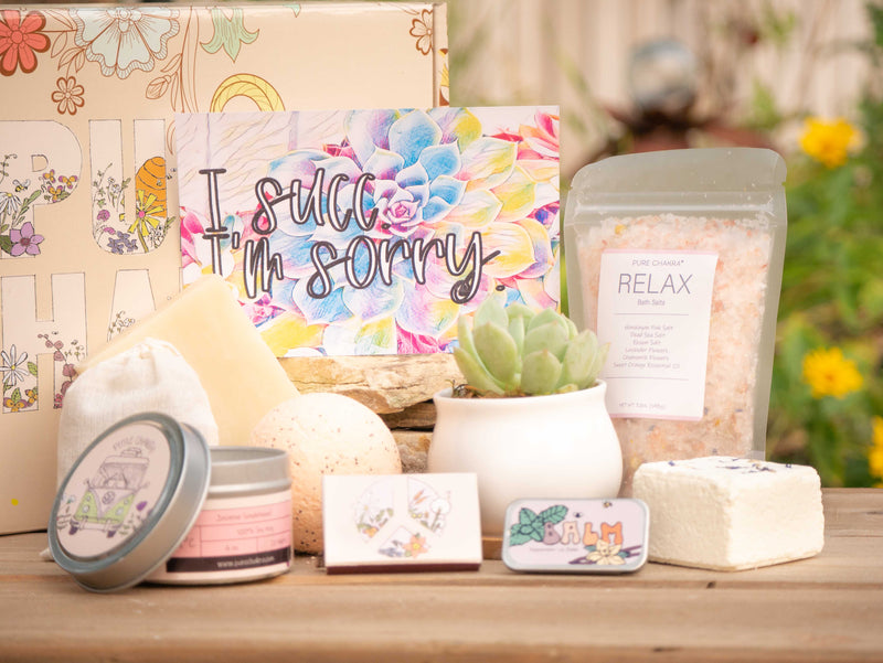 I succ I'm sorry Succulent Gift Box with relax bath salt, natural soap, bath bomb, shower steamer, candle, custom matches, lavender satchet and lip balm, in front of a decorative gift box