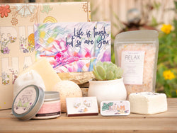 Life is tough, but so are you Succulent Gift Box with relax bath salt, natural soap, bath bomb, shower steamer, candle, custom matches, lavender satchet and lip balm, in front of a decorative gift box