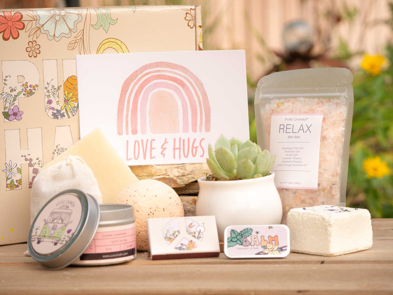 Love And Hugs Succulent Gift Box with relax bath salt, natural soap, bath bomb, shower steamer, candle, custom matches, lavender satchet and lip balm, in front of a decorative gift box