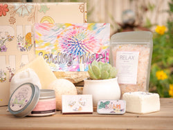 Sending Hugs Succulent Gift Box with relax bath salt, natural soap, bath bomb, shower steamer, candle, custom matches, lavender satchet and lip balm, in front of a decorative gift box