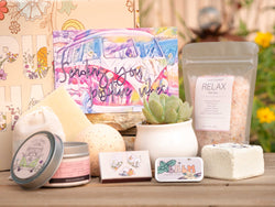 Sending you positive vibes Succulent Gift Box with relax bath salt, natural soap, bath bomb, shower steamer, candle, custom matches, lavender satchet and lip balm, in front of a decorative gift box