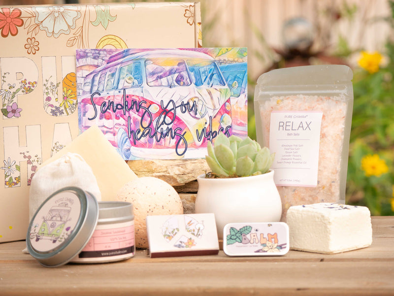 Sending you healing vibes Succulent Gift Box with relax bath salt, natural soap, bath bomb, shower steamer, candle, custom matches, lavender sachet and lip balm, in front of a decorative gift box