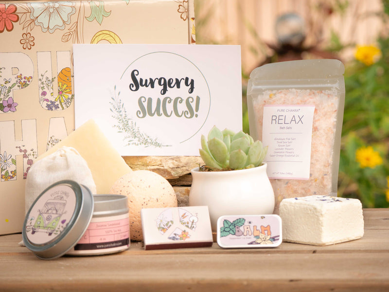 Surgery Succs! Succulent Gift Box with relax bath salt, natural soap, bath bomb, shower steamer, candle, custom matches, lavender sachet and lip balm, in front of a decorative gift box