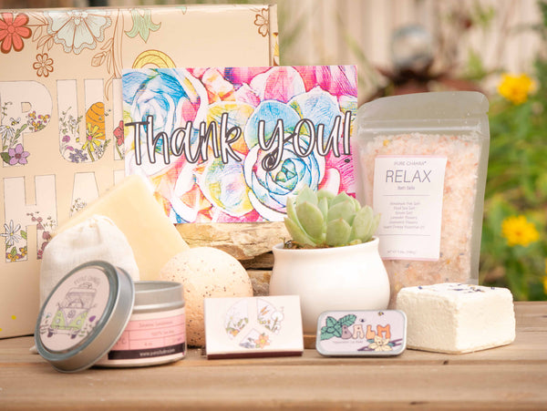 Thank you! Succulent Gift Box with relax bath salt, natural soap, bath bomb, shower steamer, candle, custom matches, lavender sachet and lip balm, in front of a decorative gift box