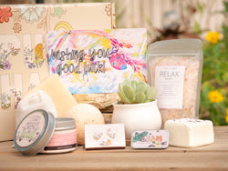 Wishing you good luck! Succulent Gift Box with relax bath salt, natural soap, bath bomb, shower steamer, candle, custom matches, lavender sachet and lip balm, in front of a decorative gift box
