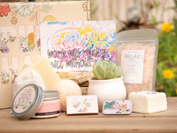 Work will really succ without you Succulent Gift Box with relax bath salt, natural soap, bath bomb, shower steamer, candle, custom matches, lavender satchet and lip balm, in front of a decorative gift box