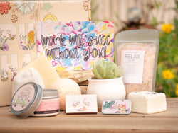 Work will succ without you! Succulent Gift Box with relax bath salt, natural soap, bath bomb, shower steamer, candle, custom matches, lavender satchet and lip balm, in front of a decorative gift box