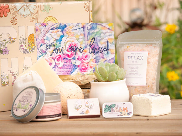 You are loved Succulent Gift Box with relax bath salt, natural soap, bath bomb, shower steamer, candle, custom matches, lavender satchet and lip balm, in front of a decorative gift box